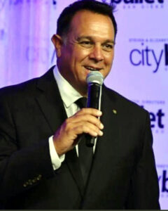 Darren Diess holding a microphone during a live auction.